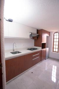 a kitchen with white cabinets and a sink and a stove at Family House in Lima