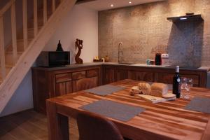 a kitchen with a wooden table with a bottle of wine at maison neuve en bois près de Pairy Daisa in Brugelette