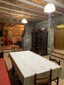 a dining room with a white table and a stone wall at Casa Gely in Fiscal