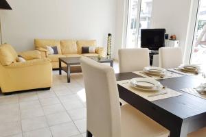 アテネにあるA Great Stay at a Comfortable Large Apartmentのリビングルーム(テーブル、椅子、ソファ付)