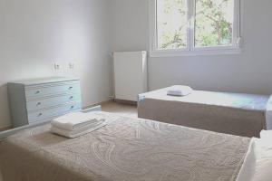 1 Schlafzimmer mit 2 Betten, einer Kommode und 2 Fenstern in der Unterkunft A Great Stay at a Comfortable Large Apartment in Athen