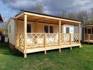 une grande cabine en bois avec une grande terrasse dans l'établissement Mobile Homes and Apartment - Terme Čatež, à Čatež ob Savi