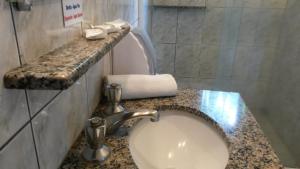a bathroom with a sink and a granite counter top at Pousada Camponesa in Picada Cafe