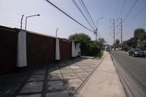 a sidewalk with a fence on the side of a street at Family House in Lima