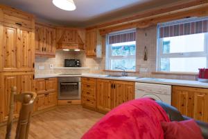 uma cozinha com armários de madeira e um forno com placa de fogão em 8 Aileach em Buncrana