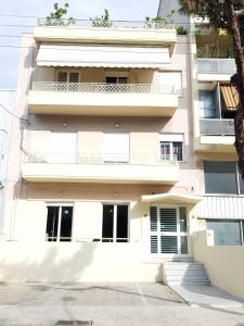 ein weißes Gebäude mit Fenstern und einem Balkon in der Unterkunft A Great Stay at a Comfortable Large Apartment in Athen