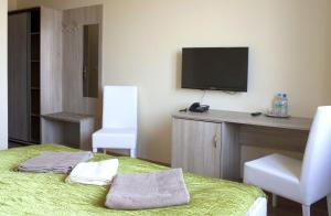 a room with a bed and a flat screen tv at Zajazd u Marcela in Goleniów