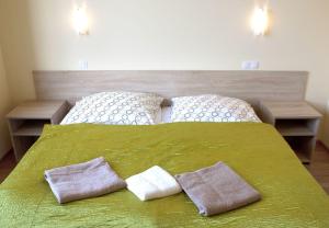a bedroom with a green bed with two pillows on it at Zajazd u Marcela in Gollnow