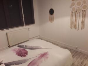ein weißes Zimmer mit einem Messer und Federn auf dem Boden in der Unterkunft Jolie maison de campagne in Fresnes-en-Woëvre