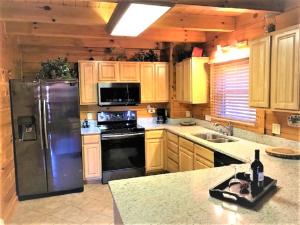 a kitchen with a stainless steel refrigerator and wooden cabinets at Knotty By Nature in Gatlinburg