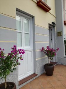een witte deur op een huis met paarse bloemen bij Casa La Palomera 1 in Valle Gran Rey