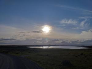 um pôr-do-sol sobre um lago com uma estrada em Southernwind - Spareroom em Stanley