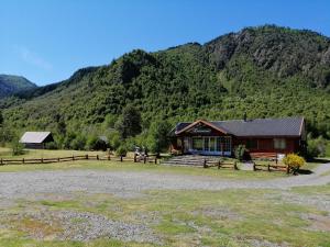 uma cabana de madeira com uma montanha ao fundo em Parque Amavida em Malalcahuello