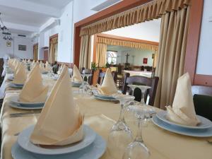 a long table with wine glasses and napkins on it at Hotel Mirni Kutak in Otočac