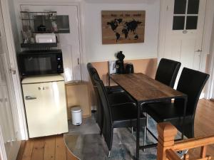 cocina con mesa, sillas y nevera en Het Huis, en Velp