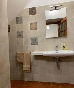 a bathroom with a sink and a mirror and towels at Casa La Stadera in Montepulciano