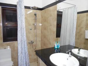 een badkamer met een wastafel en een douche bij JMF Hotel in Negombo