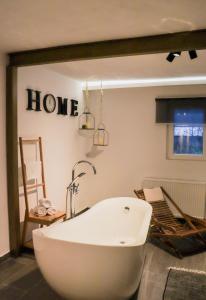 a bath tub in a room with a home sign on the wall at Villa Green Oasis in Fužine