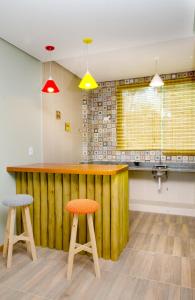 a kitchen with a wooden counter and two stools at Pousada Vie in Vale do Capao