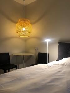 a bedroom with a bed and two chairs and a table at Harbour Living by Jutlandia in Frederikshavn