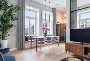 - un salon avec une table, des chaises et une télévision dans l'établissement Diamonds Home - luxury apartment in premium location, à Budapest