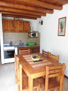 eine Küche mit einem Holztisch, auf dem ein Kuchen steht in der Unterkunft 4 SOLES in Villa Gesell