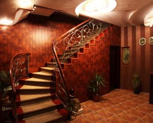 a spiral staircase in a lobby with red walls at Hotel Old Town in Kutaisi