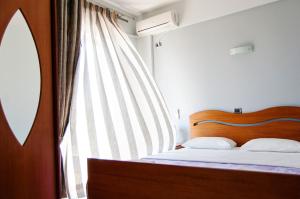 a bedroom with a bed and a large window at Dhima Hotel in Himare