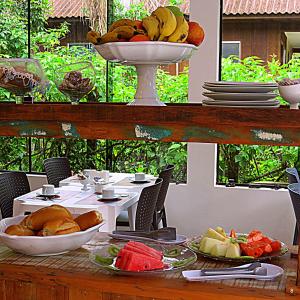 a table with a bowl of bananas and fruit on it at Recanto Abayomi in Ilha do Mel