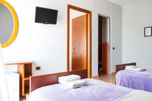 a hotel room with two beds and a mirror at Dhima Hotel in Himare