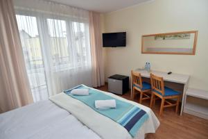 a bedroom with a bed and a desk with two chairs at Paleo Premium in Władysławowo +71 photos