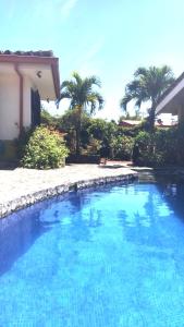 
a large white swimming pool in front of a house at Dos Palmas Studio Apartments in Alajuela
