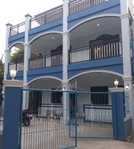 a blue building with a gate in front of it at Azulea Lodging House Oslob in Oslob