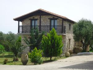 a stone house with a balcony on top of it at Valentino Villas & Apartments in Vasilikos