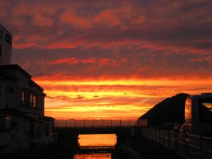 青森市にある宿屋 つばきの空の水の上の夕日