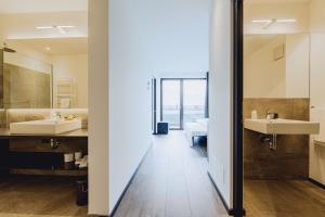 een badkamer met twee wastafels en twee spiegels bij Hotel Raffl in Bolzano +49 foto's