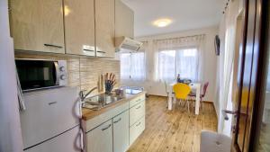 eine Küche mit einem weißen Kühlschrank und einem Tisch in der Unterkunft Studio apartment Margarita in Opatija