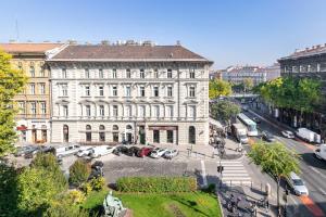 un grand bâtiment blanc avec des voitures garées dans un parking dans l'établissement Diamonds Home - luxury apartment in premium location, à Budapest