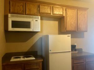 a kitchen with a white refrigerator and a microwave at Lone Star Inn & Suites in Killeen