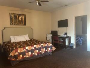 a hotel room with a bed and a desk and a television at Lone Star Inn & Suites in Killeen