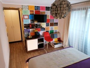 a bedroom with a colorful wall with a red chair at iVΛVƏV IS US in Eforie Sud