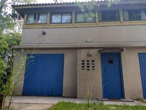 una casa con dos puertas de garaje azules delante de ella en Casa grande con jardin en Ostende