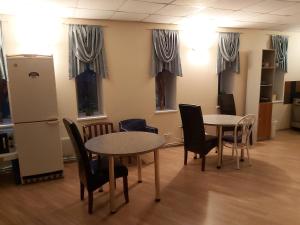 a room with two tables and chairs and windows at Majaka Hostel in Tallinn