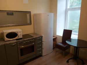uma cozinha com um frigorífico e uma mesa com um micro-ondas em Viva Nord Hotel em Talin