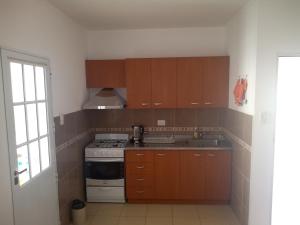 孫察列斯的住宿－Departamento los sunchos，厨房配有木制橱柜和炉灶烤箱。