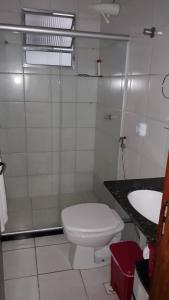 Baño blanco con aseo y lavamanos en Suíte e Quarto em apartamento familiar, Praia do Morro!, en Guarapari