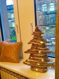 un arbre de Noël en or assis sur un rebord de fenêtre dans l'établissement Altbauwohnung im Herzen von Karlsruhe, à Karlsruhe