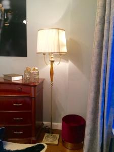 eine Lampe neben einer Kommode neben einem Bett in der Unterkunft Altbauwohnung im Herzen von Karlsruhe in Karlsruhe