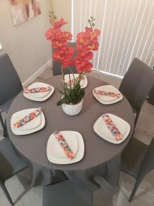a dining room table with plates and flowers on it at Coral Springs Paradise in Coral Springs