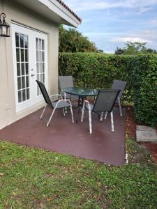 een patio met een tafel en stoelen voor een huis bij Coral Springs Paradise in Coral Springs